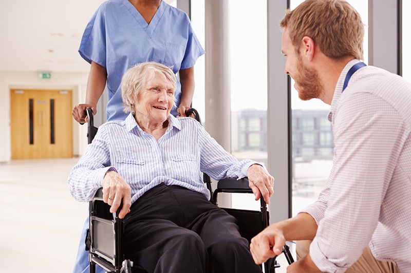 Older woman in a wheelchair talking with a doctor in a long-term care facility in Monroe, LA