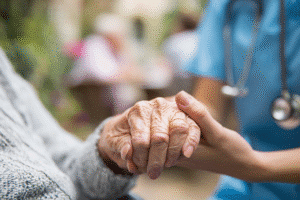 Nurse holding hand of short-term rehab resident at St. Joseph Rehab in Monroe, LA