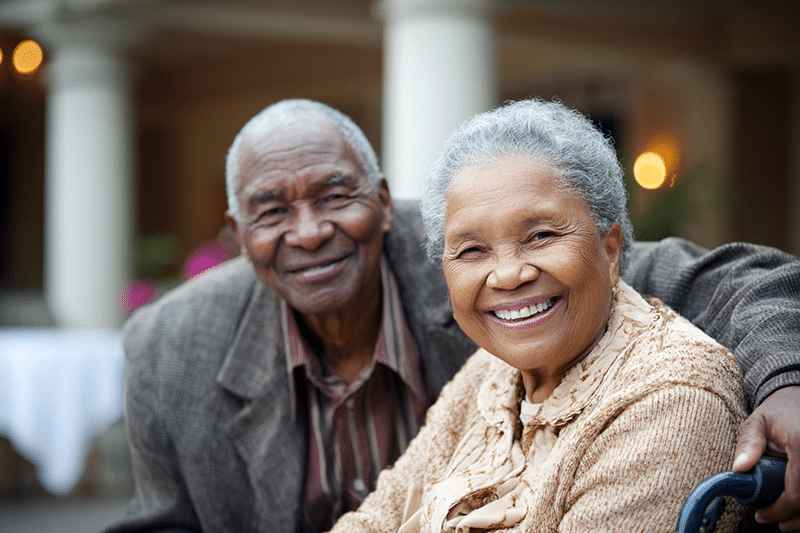 A happy elderly couple smiling at the camera in an assisted living facility in Monroe, LA